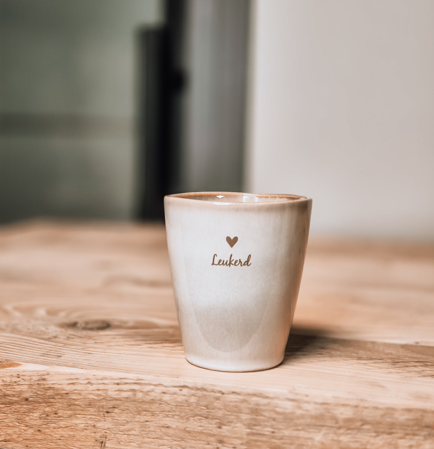 Een beige mok gegraveerd met de tekst leukerd en een hartje.