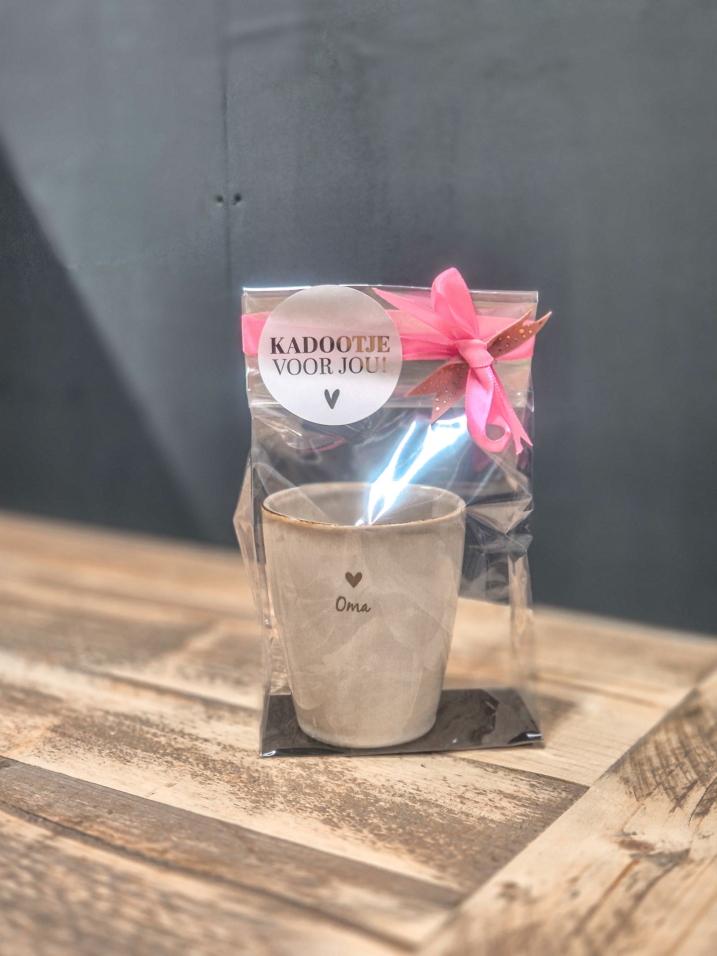 Gepersonaliseerde mok gegraveerd met een hartje en tekst oma. Leuk verpakt met een roze strik en een sticker