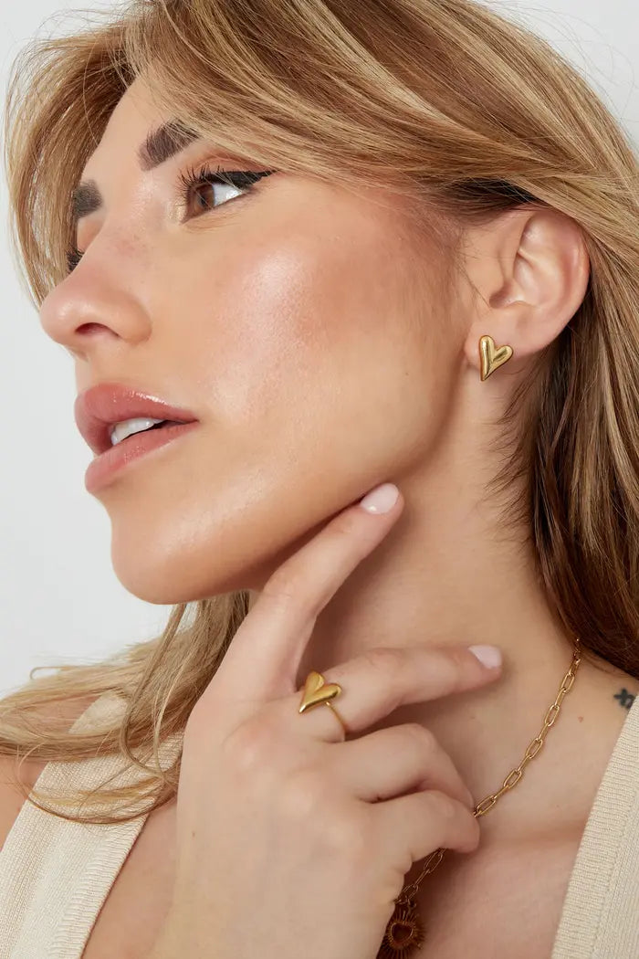 Combinatie van goudkleurige stainless steel oorbellen met hart en bijpassende ring een perfecte set voor een elegante look.