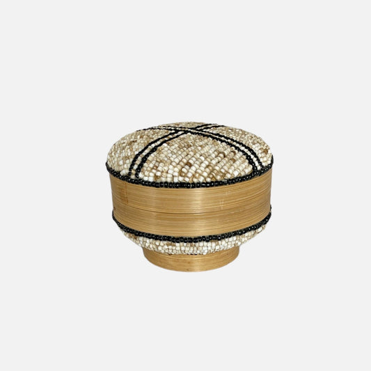 Een prachtige ronde doos met kralen in een een gouden zandkleur en een zwart patroon. Perfect om kleine spullen in op te bergen of als decoratie te gebruiken. 