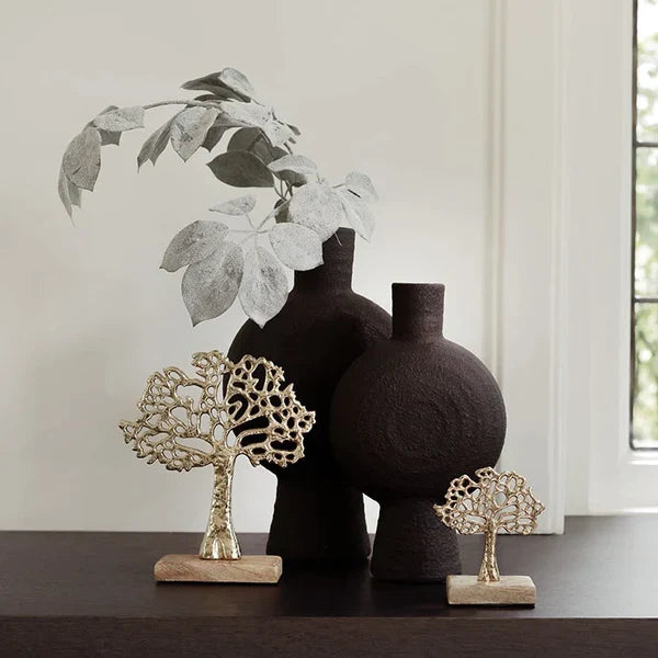 zwarte vazen 1 hoog en 1 is wat lager met daarin een sierlijke tak en luxe gouden ornamenten ervoor.