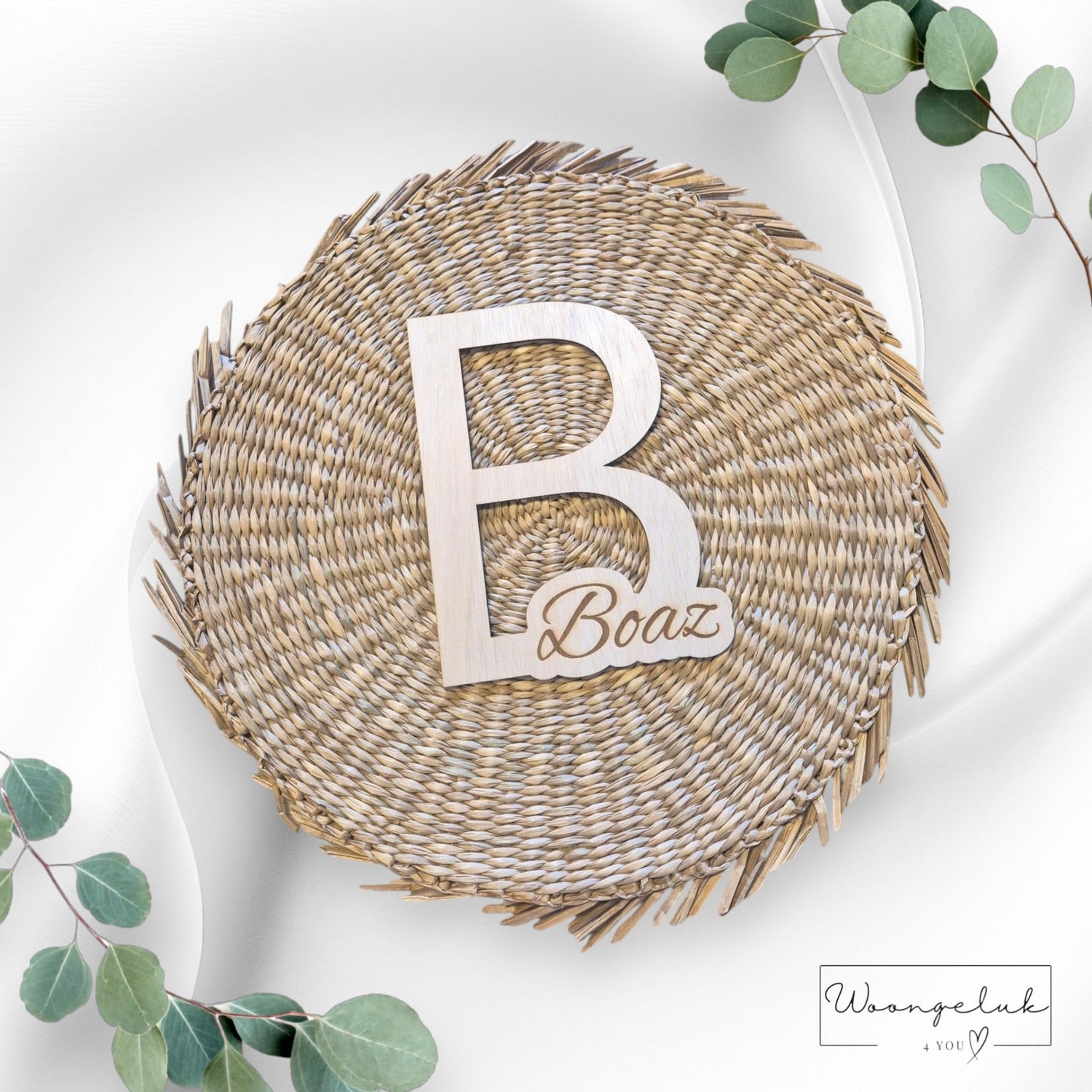 een gevlochten cirkel met daarop de letter B met daarin gegraveerd de naam Boaz