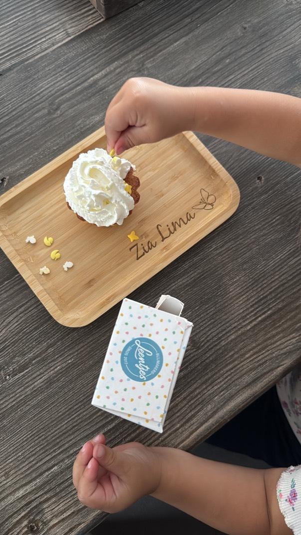 Gepersonaliseerd broodplankje met naam en vlinder gegraveerd, een meisje is een upcak aan het versieren.