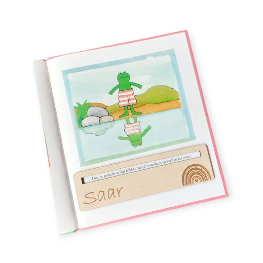 BlZ van een boek, met daarop een houten gepersonaliseerde leeswijzer met naam en een regenboog