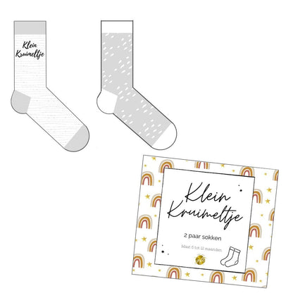 Schattige giftbox met 2 paar grijze babysokjes (maat 62-68), met de tekst "Klein Kruimeltje". Het doosje heeft regenboogillustraties en is perfect als kraamcadeau.