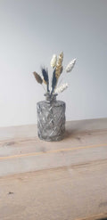 Charmant klein glazen vaasje met een unieke selectie droogbloemen (wisselend per bestelling). Perfect als sfeervolle decoratie of cadeau.