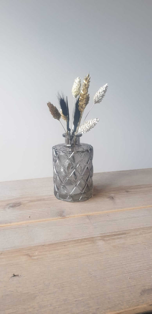 Charmant klein glazen vaasje met een unieke selectie droogbloemen (wisselend per bestelling). Perfect als sfeervolle decoratie of cadeau.