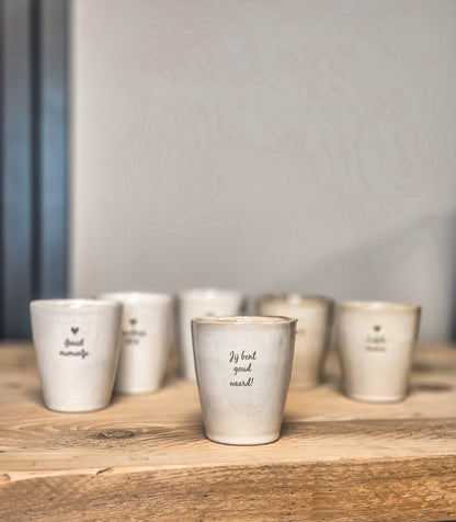 Op de voorgrond mokje met tekst jij bent goud waard, daarachter staan nog gepersonaliseerde mokjes met andere teksten