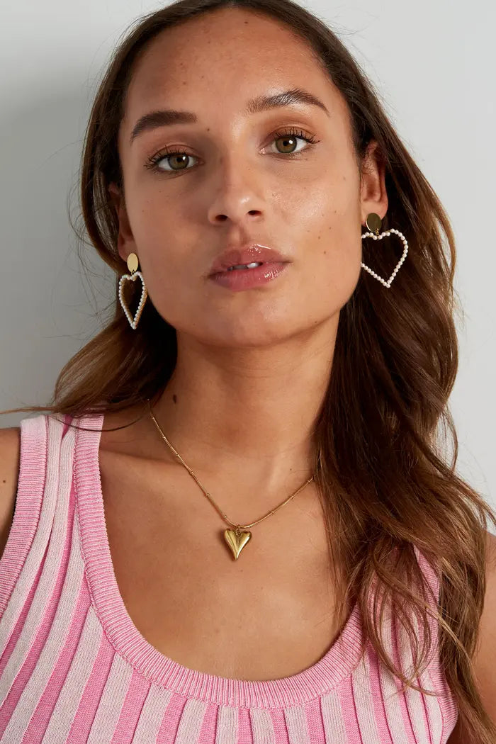 Goudkleurige bolletjes ketting met hart, gedragen door model, een elegante en romantische toevoeging aan elke outfit.