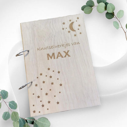 Houten A4 bewaarbundel met gepersonaliseerde tekst "Knutselwerkjes van [Eigen Naam]" en een ontwerp met sterren en de maan, perfect voor het bewaren van tekeningen en knutselwerkjes.