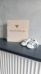 Sfeerfoto van de houten bewaarbundel "Mijn Geboortekaartjes" op een stijlvolle achtergrond, perfect voor het bewaren van geboortekaartjes.