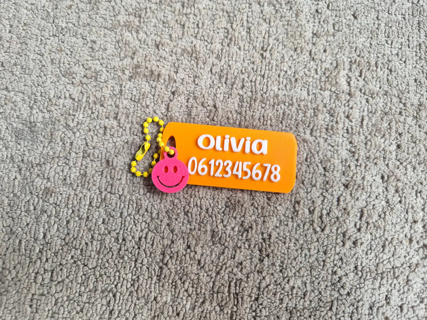 SOS Sleutelhanger oranje met naam en telefoonnummer en een smiley hanger