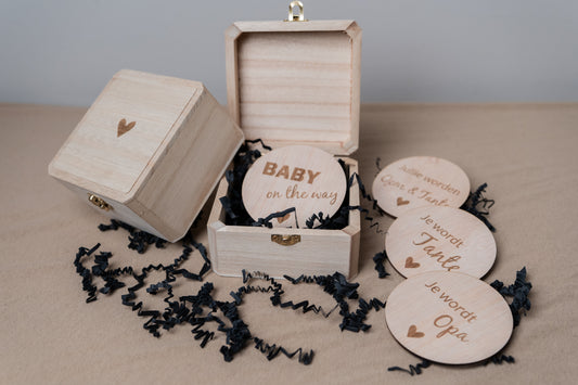 een kistje voor een zwangerschapsaankondiging met daarom heen liggend alle cirkels die je kan kiezen. Zoals je wordt opa/oma of oom/tante.